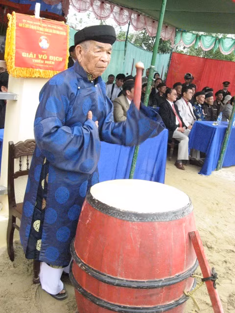 Đại diện bô lão làng Sình đánh trống khai hội và trống vào cuộc đấu vật.