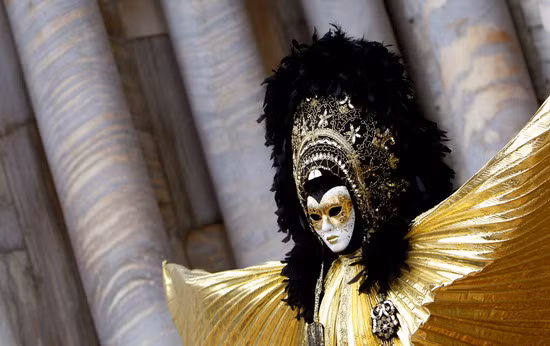 A masked reveller poses in Piazza San Marco during the Venetian Carnival in Venice, Italy 