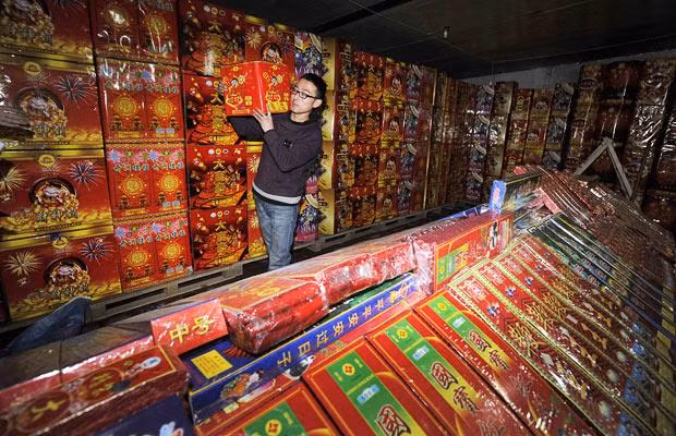 A seller carries firework products for sale at a stall in Qingdao, in eastern China’s Shandong province