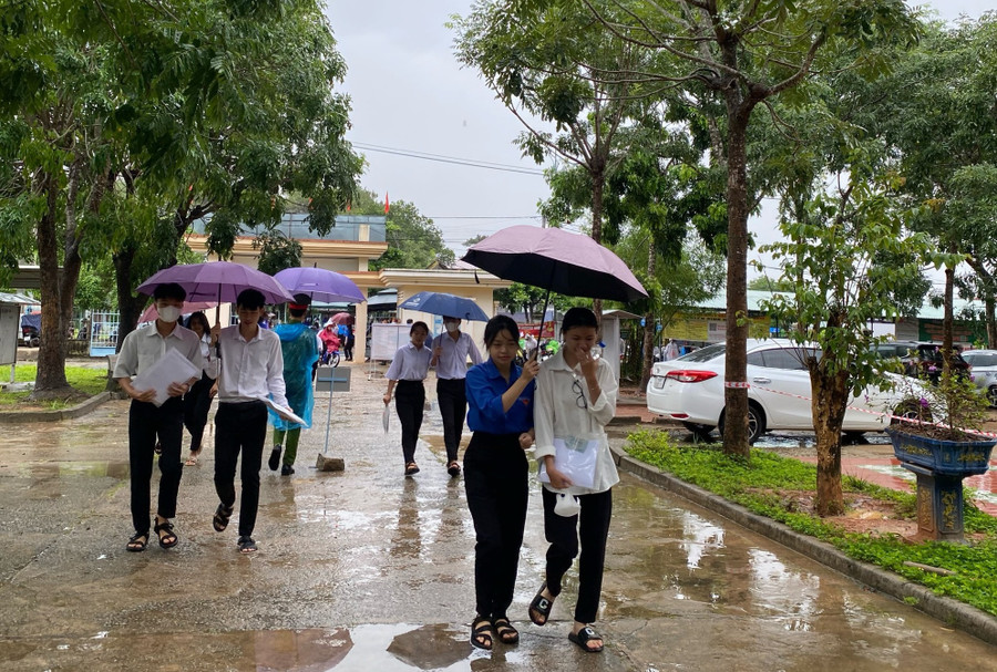 Cơn mưa bất chợt khiến các thí sinh không kịp chuẩn bị áo mưa, lực lượng công an, tình nguyện viên đã che dù, đưa các thí sinh vào điểm thi.