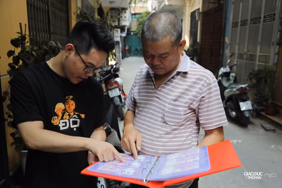 Anh Phùng Văn Hùng - chủ một cửa hàng chuyên về sưu tập tiền đang giới thiệu cho khách về bộ tiền 0 Euro lưu niệm cho Vòng chung kết World Cup 2022.