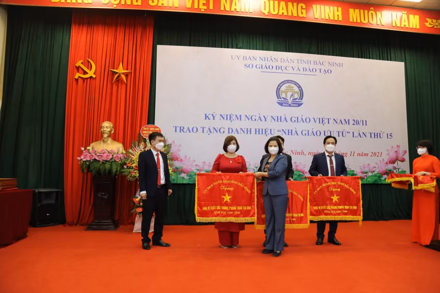 Cô Nguyễn Thị Hương, hiệu trưởng, đại diện nhà trường nhận Cờ thi đua năm học 2020-2021 của UBND tỉnh.