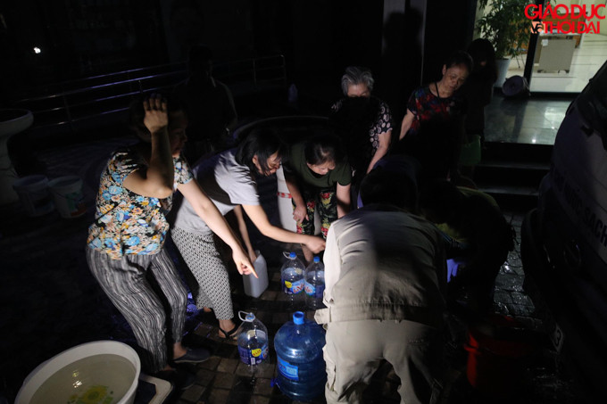 Đông người dân tay cầm bình to, bình nhỏ để sẵn chỉ đợi lấy nước sạch về.