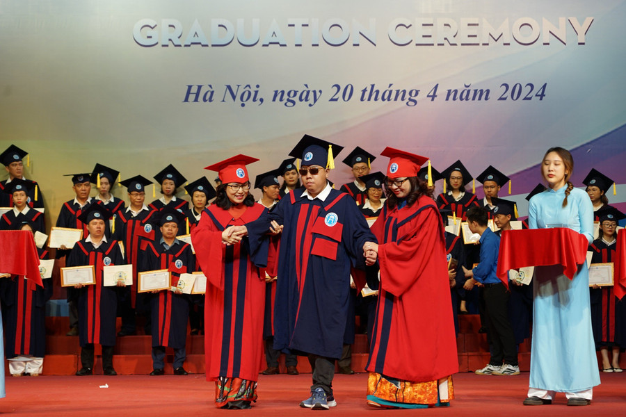 Lãnh đạo Trường ĐH Mở Hà Nội hỗ trợ sinh viên khiếm thị nhận bằng tốt nghiệp.