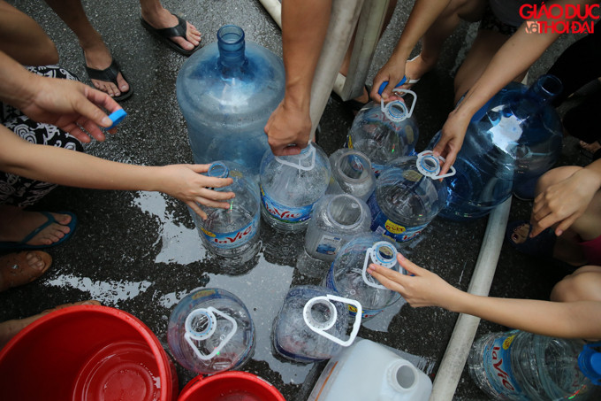 Mọi đồ dùng có thể đựng được nước đều được người dân mang đến để lấy nước về nhà.