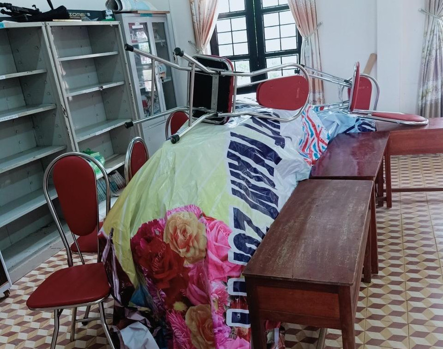 Sách vở, thiết bị dạy học được đặt lên cao, phủ bạt để tránh bị ướt.