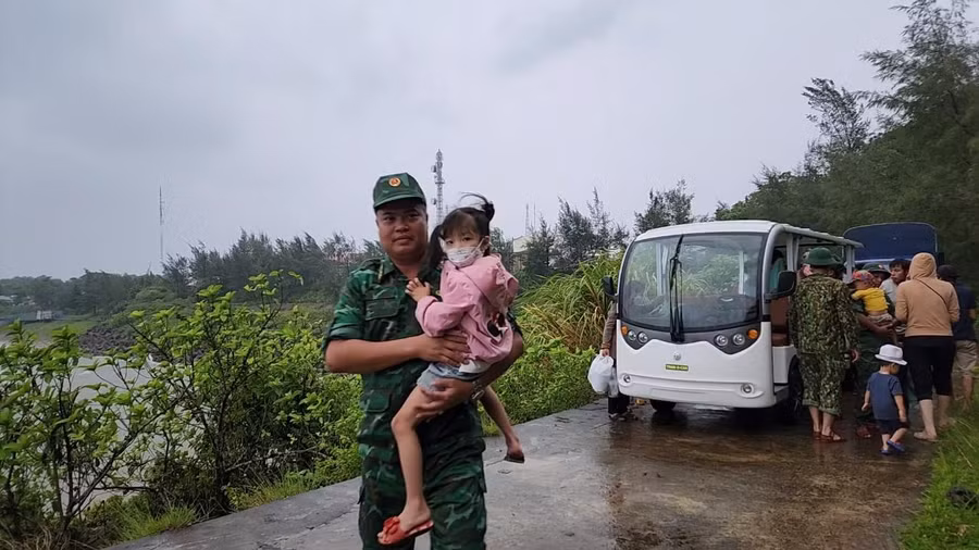 Bộ đội bế các em nhỏ di chuyển vào hầm.