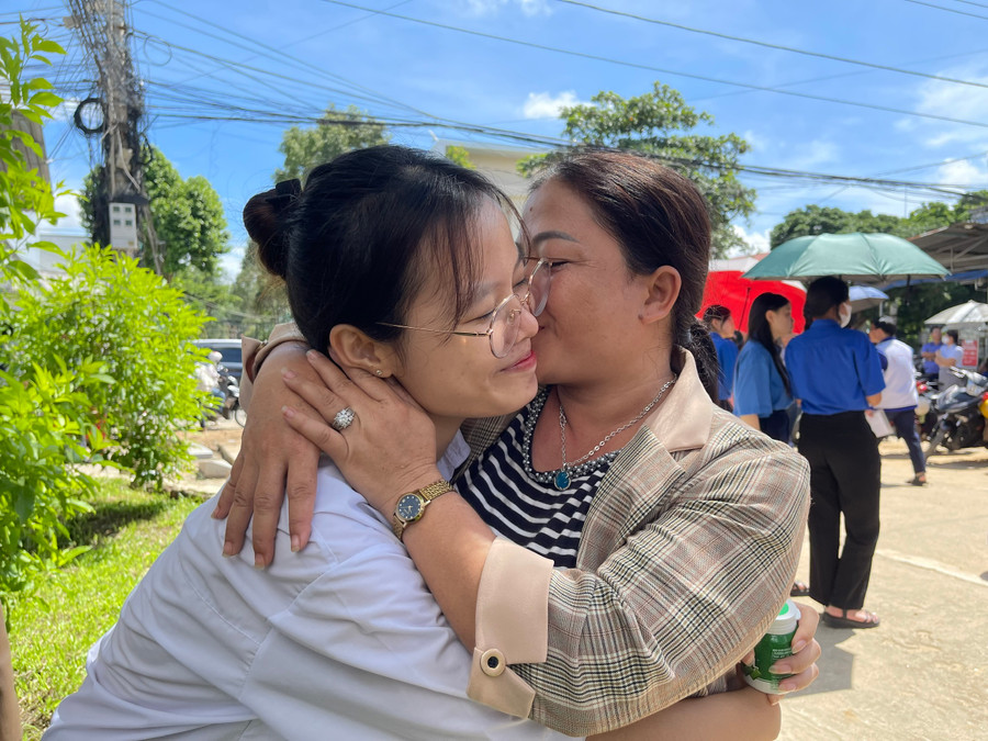 Chị Phan Thị Hiệp chúc mừng con gái hoàn thành tốt môn thi đầu tiên bằng một nụ hôn. Chị Phan Thị Hiệp chúc mừng con gái hoàn thành tốt môn thi đầu tiên bằng một nụ hôn.