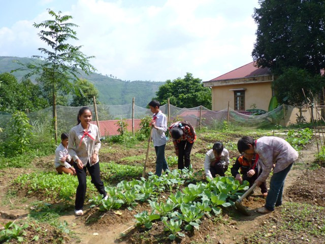 Các em học sinh bán trú trường THCS Nậm Đét chăm sóc vườn rau