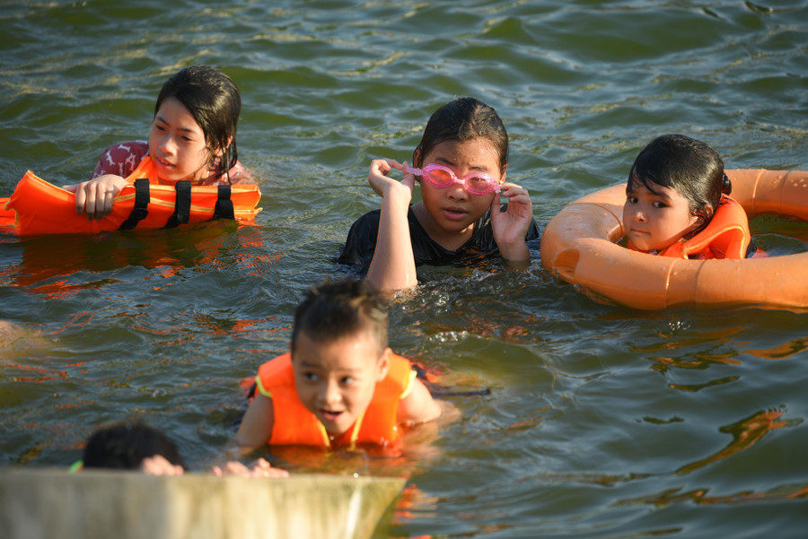 Tại đây, các bạn nhỏ được gia đình trang bị áo phao, phao....