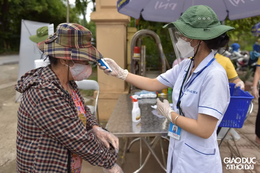 Người dân vào trong khu vực "siêu thị 0 đồng" đều sẽ phải rửa tay sát khuẩn, đo nhiệt độ và đeo găng tay do ban tổ chức phát.