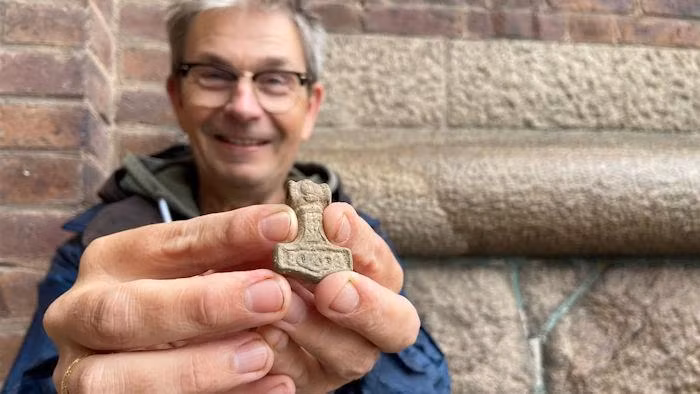 Chuyên gia Per Wranning cùng chiếc bùa Mjölnir thời Viking. Ảnh: Patricia Torvalds/Sveriges Radio.