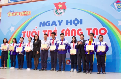 Ông Nguyễn Đức Quang - Tổng Biên tập báo Thiếu niên Tiền phong - (thứ ba từ phải qua) và bà Trần Lưu Hoa - Trưởng phòng GD&ĐT quận Hai Bà Trưng trao tặng các suất học bổng cho 10 em học sinh xuất sắc, vượt khó học tốt của THCS Tây Sơn.