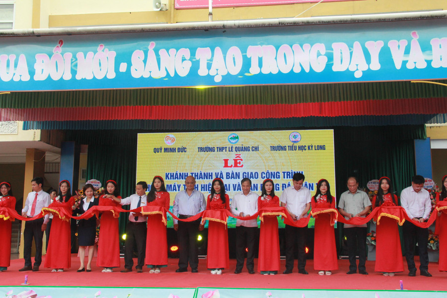 Các đại biểu cắt băng khánh thành và bàn giao phòng học máy tính và sân bóng nhân tạo.