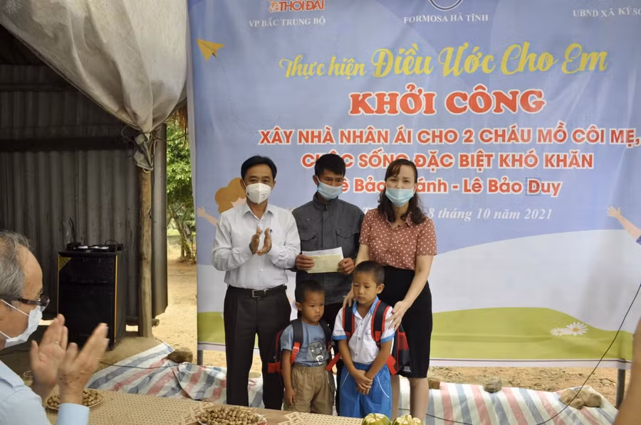 Ông Trần Thế Dũng, bà Đặng Thị Quỳnh Diệp tặng quà là áo quần, cặp sách cho 2 cháu Bảo Khánh, Bảo Duy.