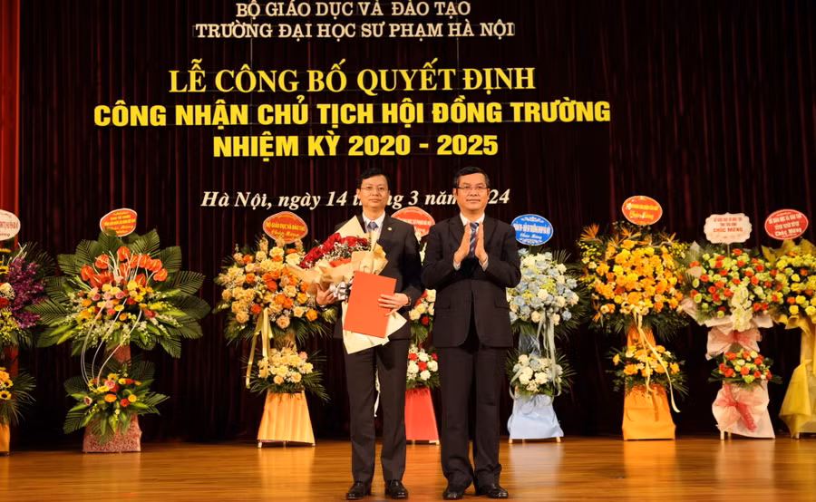 Thứ trưởng Bộ GD&ĐT Nguyễn Văn Phúc (bên phải) trao quyết định và tặng hoa chúc mừng tân Chủ tịch Hội đồng Trường ĐH Sư phạm Hà Nội.