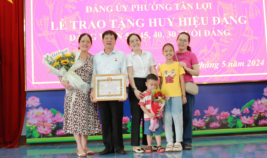 Niềm tự hào của con, cháu khi cha, ông nhận Huy hiệu Đảng. (Ảnh: Thành Tâm)
