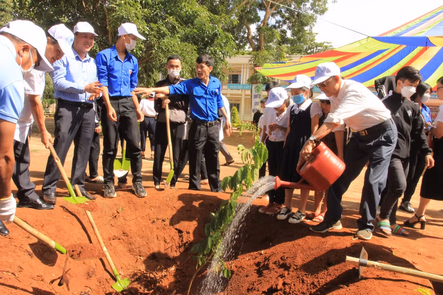 Các đại biểu tham gia trồng cây xanh trong khuôn viên trường Tiểu học Nguyễn Văn Bé, huyện Krông Pắc.