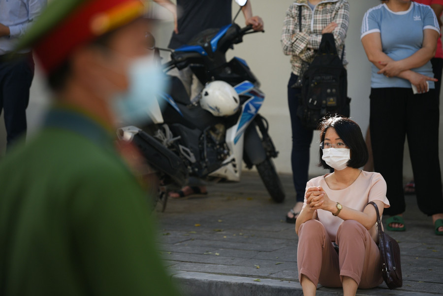 Những khoảng khắc lo lắng của những bậc phụ huynh ngồi đợi phía bên ngoài cổng trường, chờ con em mình ra ngoài trường thi.