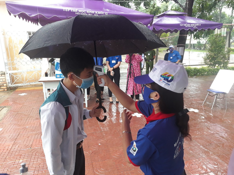 Mặc dù trời mưa nhưng tình nguyện viên không quên nhiệm vụ đo thân nhiệt cho thí sinh. Mặc dù trời mưa nhưng tình nguyện viên không quên nhiệm vụ đo thân nhiệt cho thí sinh.