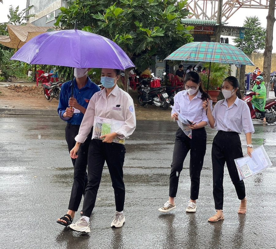 Chiều 7/7, trời mưa lớn, tình nguyện viên tại điểm thi Trường THPT Trần Quốc Tuấn (huyện Đăk Hà) che dù cho thí sinh vào điểm thi. Chiều 7/7, trời mưa lớn, tình nguyện viên tại điểm thi Trường THPT Trần Quốc Tuấn (huyện Đăk Hà) che dù cho thí sinh vào điểm thi.