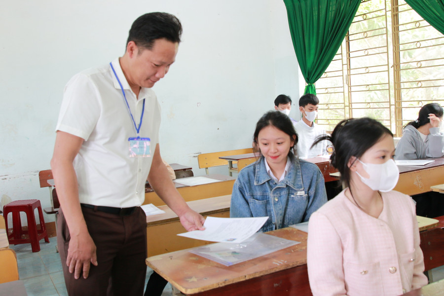 Cán bộ coi thi tại điểm thi Trường THPT Trần Hưng Đạo kiểm tra giấy tờ của thí sinh. (Ảnh: Thành Tâm) Cán bộ coi thi tại điểm thi Trường THPT Trần Hưng Đạo kiểm tra giấy tờ của thí sinh. (Ảnh: Thành Tâm)