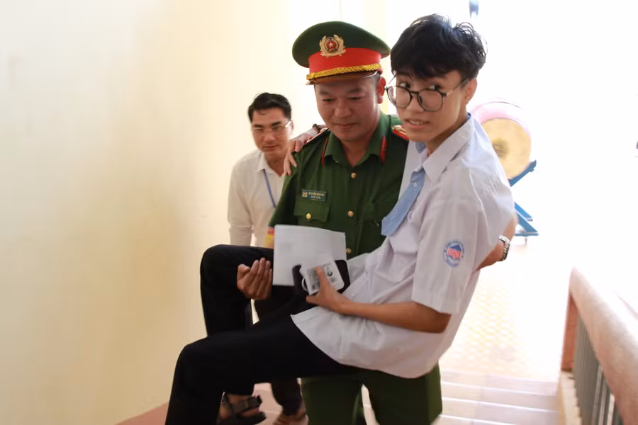 Đôi chân chưa tự đi, nhưng thí sinh Nguyễn Đình Cương yên tâm vì đã có lực lượng Công an hỗ trợ trong suốt quá trình dự thi. (Ảnh: Thành Tâm)