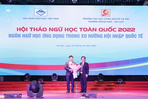 PGS. TS Nguyễn Lân Trung (phải) tặng hoa kỉ niệm cho TS Hoàng Ngọc Tuệ (trái).