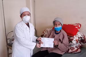 Cán bộ y tế huyện Hữu Lũng trao giấy ra viện cho cụ bà Nông Thị Phít. Ảnh: Trung tâm y tế huyện Hữu Lũng.