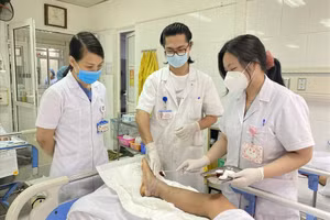 Các bác sĩ kiểm tra chân bệnh nhân sau ca phẫu thuật. Ảnh: BVCC.