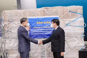 Bộ trưởng Bộ Công an Tô Lâm và Bộ trưởng Bộ Y tế Nguyễn Thanh Long bên lô hàng vật tư, trang thiết bị y tế hỗ trợ điều trị Covid-19. Ảnh: Trần Minh.