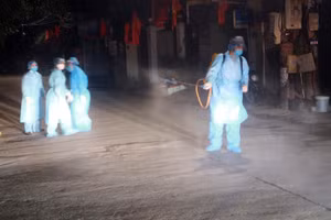 Lực lượng chức năng phun khử khuẩn khu vực anh P.T.D sinh sống. Ảnh: TTXVN.