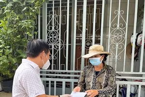 Người lao động nghèo ở quận Gò Vấp nhận tiền từ gói hỗ trợ của TP Hồ Chí Minh. Ảnh: Minh Khang.