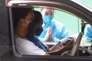 Những người bị nhiễm Covid-19 với các triệu chứng nhẹ lái xe đến và nhận thuốc điều trị Covid-19 tại Pathum Thani, Thái Lan. Ảnh: Apichit Jinakul.
