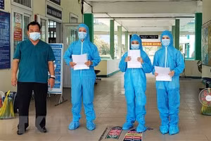 Bác sỹ Lê Thành Phúc trao giấy chứng nhận khỏi bệnh cho BN3396, BN3397, BN3398. Nguồn: Văn Dũng/TTXVN