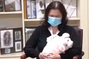 Chị Phương Loan ôm chặt con heo do chồng tặng. Ảnh cắt từ clip.