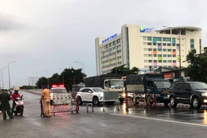 Lực lượng chức năng dừng, kiểm tra phương tiện lưu thông thực hiện phòng, chống dịch bệnh Covid-19 tại khu vực cầu Vĩnh Bình, TP.Thuận An. Ảnh: Báo Bình Dương.