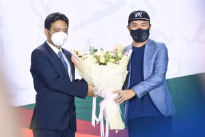 Thứ trưởng Bộ Văn hóa-Thể thao và Du lịch Hoàng Đạo Cương tặng hoa cho nhạc sỹ Huy Tuấn - tác giải bài hát chính thức của Đại hội Thể thao Đông Nam Á lần thứ 31. Ảnh: Bùi Lượng.