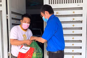 Đoàn viên thanh niên quận Bình Tân đi chợ hộ cho người dân. Ảnh: SA LIN.