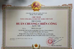 Chủ tịch nước Nguyễn Xuân Phúc truy tặng Huân chương Chiến công hạng Nhì cho Đại uý Phan Tấn Tài. Ảnh: CAND.
