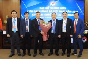 Quyền chủ tịch Liên đoàn Bóng đá Việt Nam Trần Quốc Tuấn nhận hoa chúc mừng từ Nguyên Chủ tịch Liên đoàn Bóng đá Việt Nam khóa VIII Lê Khánh Hải. Ảnh: TTXVN.