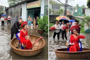 Cô dâu Khánh Vy được chú rể đẩy bằng thuyền thúng, di chuyển qua đoạn đường ngập nước. Ảnh: Nguyễn Kỳ Lu.