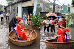 Cô dâu Khánh Vy được chú rể đẩy bằng thuyền thúng, di chuyển qua đoạn đường ngập nước. Ảnh: Nguyễn Kỳ Lu.