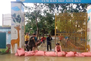 Giáo viên cụm xóm Bục, Trường Mầm non Đồng Văn 2 (huyện Tân Kỳ, Nghệ An) dùng bao cát ngăn không cho nước lũ tràn vào sân.