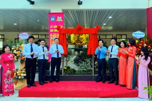 Các đại biểu thực hiện nghi thức gắn biển công trình tại Trường Tiểu học Kim Liên.