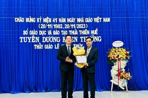 Đại diện Sở GD&ĐT tỉnh Thừa Thiên - Huế tặng hoa và giấy khen cho thầy Lê Ngọc Thùy. (Ảnh: L.C).