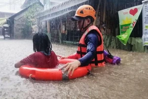 Nhân viên cứu hộ đưa người đi sơ tán.