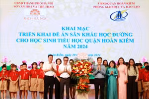 Đại diện ngành GD-ĐT quận Hoàn Kiếm và các em học sinh tặng hoa chúc mừng các nghệ sĩ.