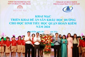 Đại diện ngành GD-ĐT quận Hoàn Kiếm và các em học sinh tặng hoa chúc mừng các nghệ sĩ.