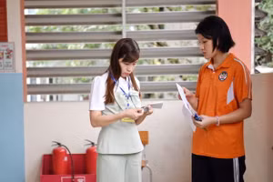 Giám thị kiểm tra đồng hồ của thí sinh trước giờ vào phòng thi.